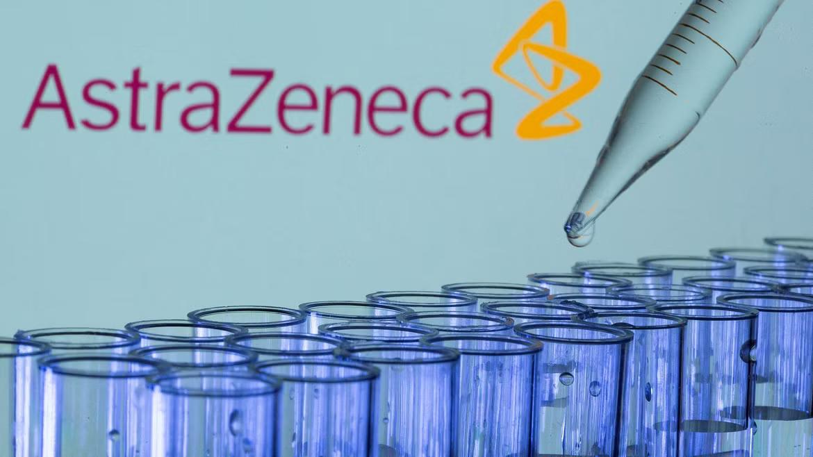 Test tubes are seen in front of a displayed AstraZeneca logo in this illustration taken