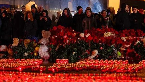 People stand in front of lit candles outside the Crocus City Hall concert venue