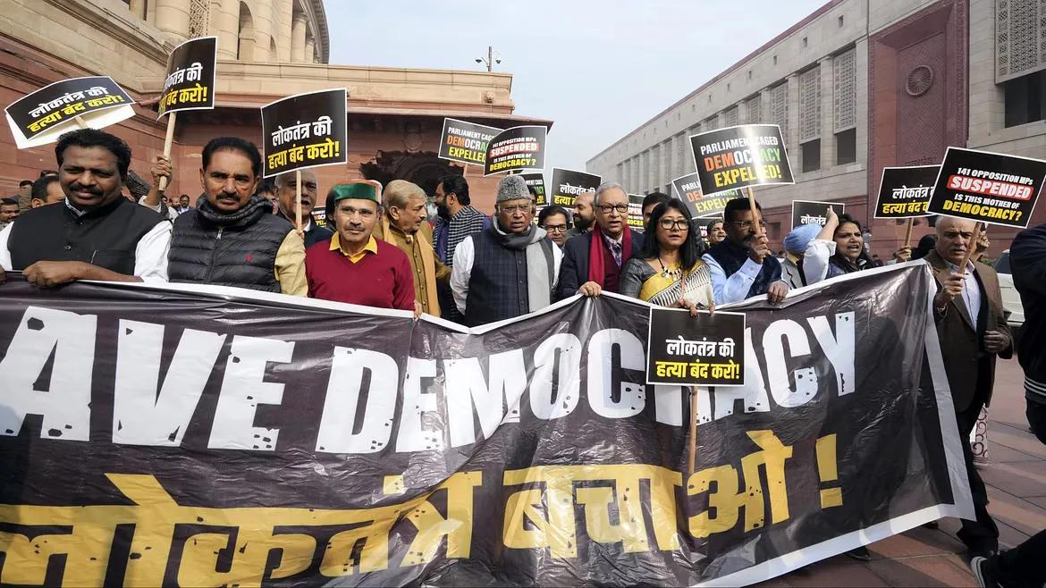 Leader of Opposition in the Rajya Sabha Mallikarjun Kharge with suspended opposition MPs during a protest over their suspension at Mahatma Gandhi statue