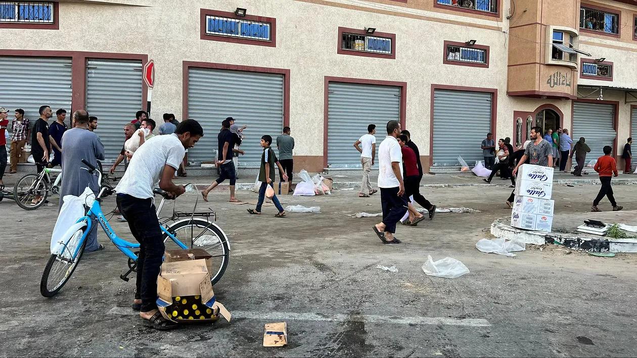 Palestinians carry food supplies near a UNRWA