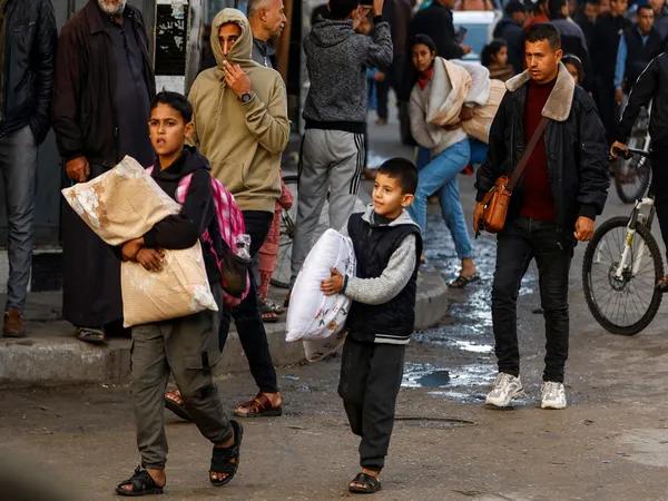 Displaced Palestinian children make their way home, during a temporary truce between Hamas and Israel