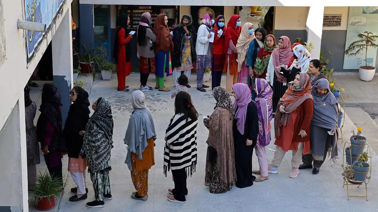 Voters queue to vote at a polling station in a school during a general election, in Islamabad
